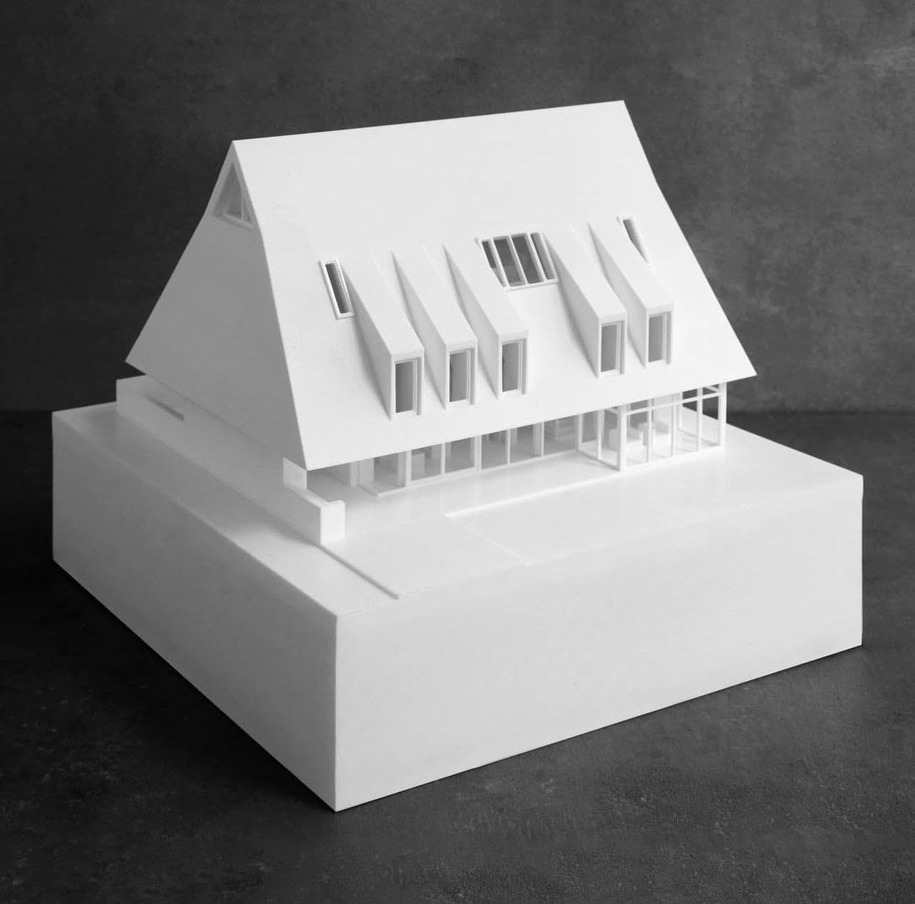 Study model — a white massing model of a pitched-roof house with deep dormers