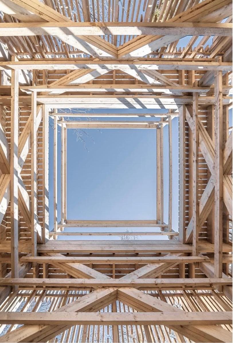 Observation — looking up through a timber lattice tower to a square of sky